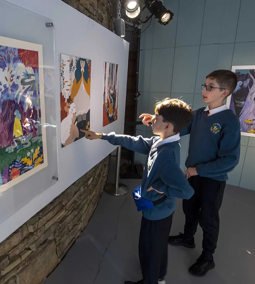 Two boys in school uniforms discuss artwork at the Arts Centre Tralee Kerry.