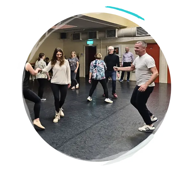 Photo of a man teaching exercise to a group of women in a dance studio