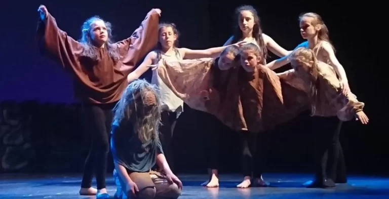 Group of children on stage performing interpretive dance