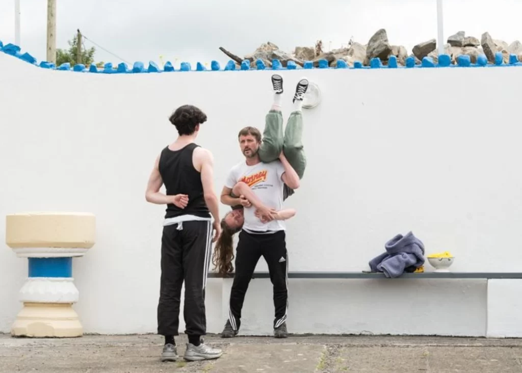 Three people practice acrobatics; experience Siamsa Tíre traditional Irish arts performances.