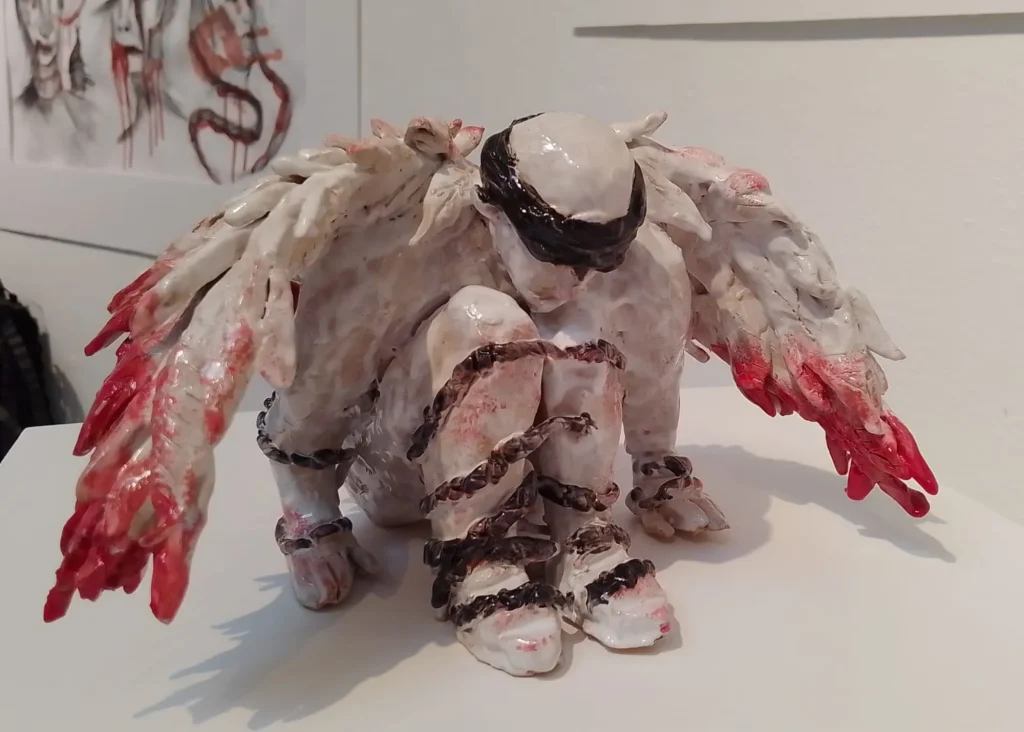 A ceramic figure crouches, blindfolded, like a Siamsa Tíre theatre Tralee performer.