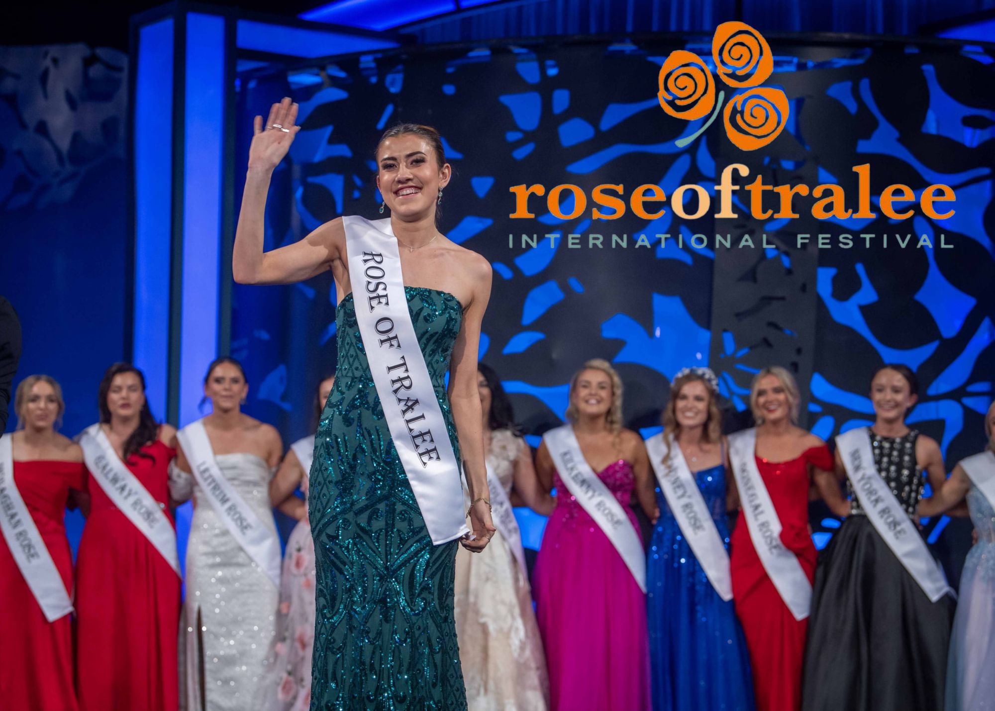 A woman in a sash waves on stage at the Arts Centre Tralee Kerry during Rose of Tralee festival.