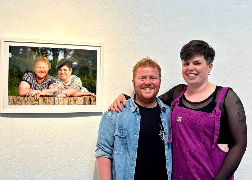 Two people smiling by their photo at Siamsa Tíre, home of traditional Irish arts performances.