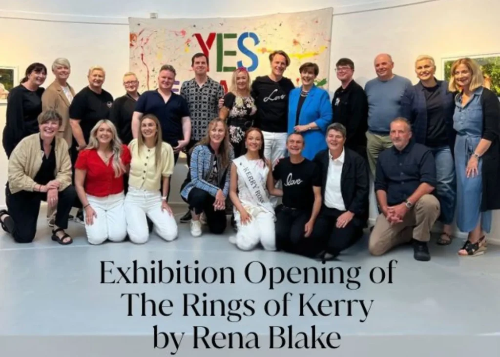 A group poses at an art exhibition in Siamsa Tíre theatre Tralee, with a colorful "YES" sign behind.