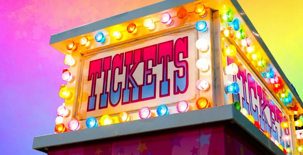Colorful ticket booth sign at Arts Centre Tralee Kerry, lit with multicolored bulbs and a bright sky.