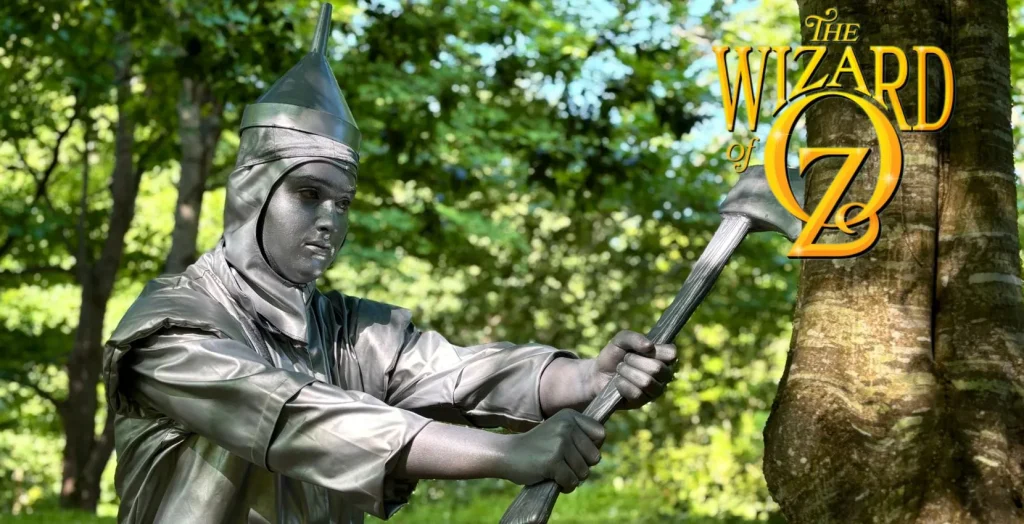 Person as the Tin Man with an axe by a tree, promoting Siamsa Tíre theatre Tralee live show.