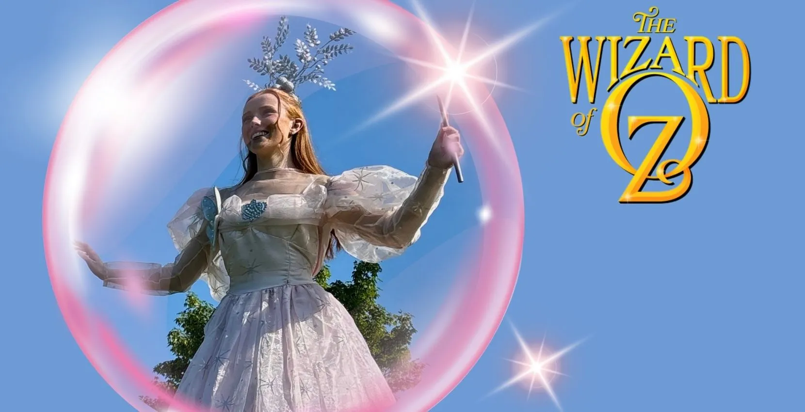 A smiling woman in a white dress holds a wand at Siamsa Tíre traditional Irish arts performances.
