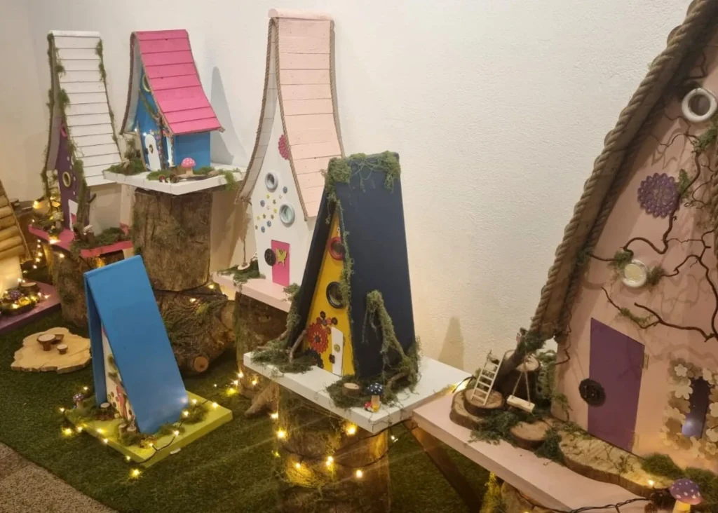 Colorful fairy house models with lights and moss, inspired by Siamsa Tíre traditional Irish arts.