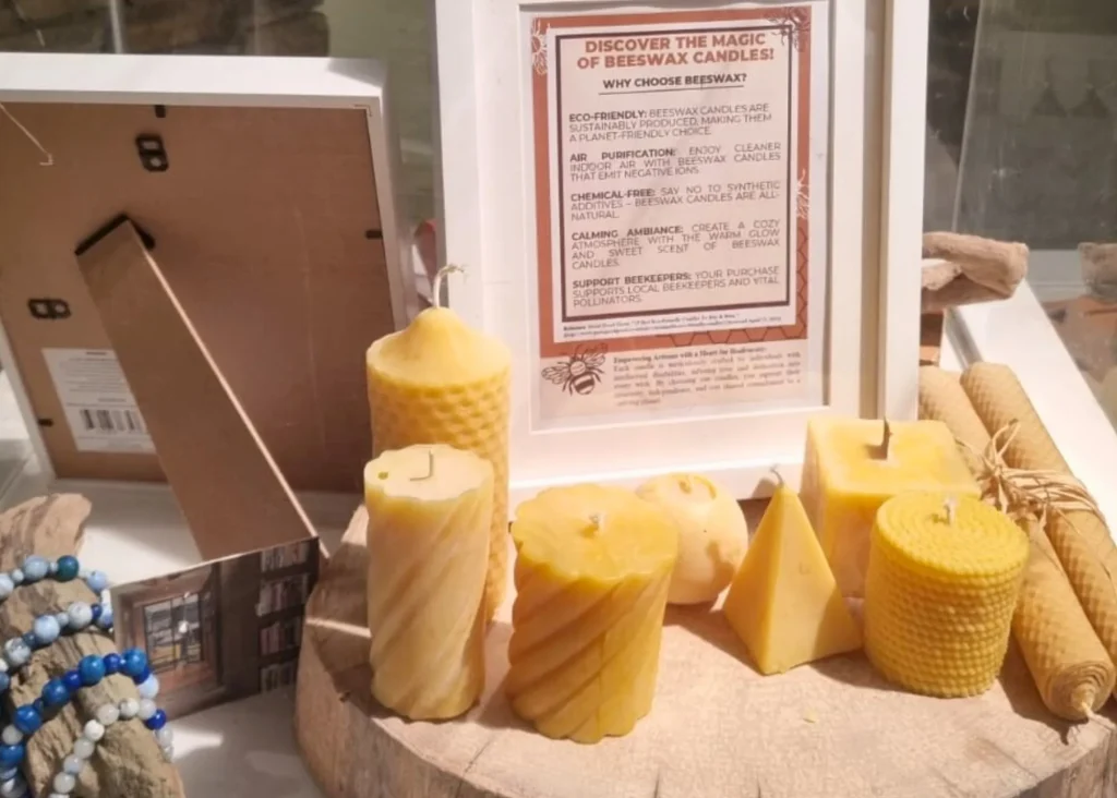 Various shapes of yellow beeswax candles at Arts Centre Tralee Kerry, info sign behind.