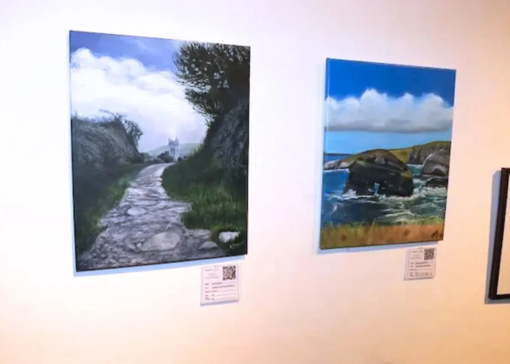 Two landscape paintings hanging on a wall