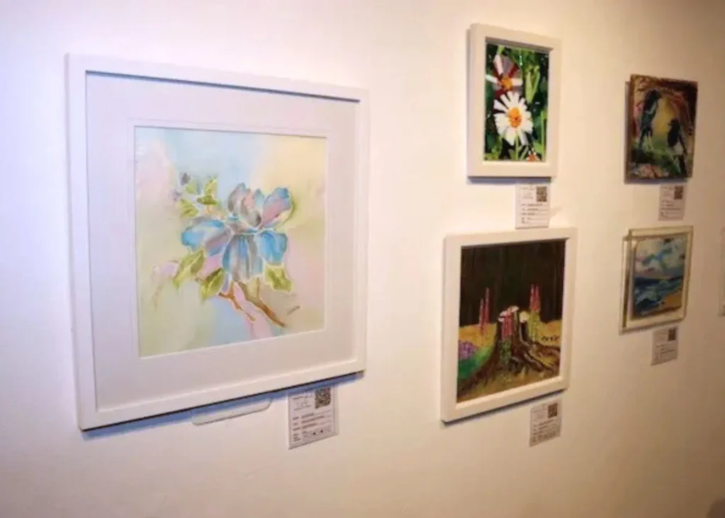 A collection of paintings of flowers hanging on a wall