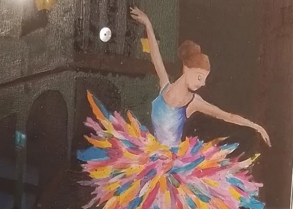 Image of a painting of a ballerina with brown hair in a bun and a multicolour tutu