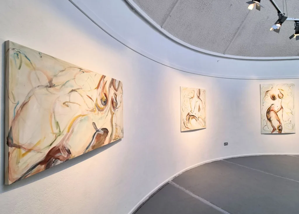 Photo of paintings hanging in an art gallery