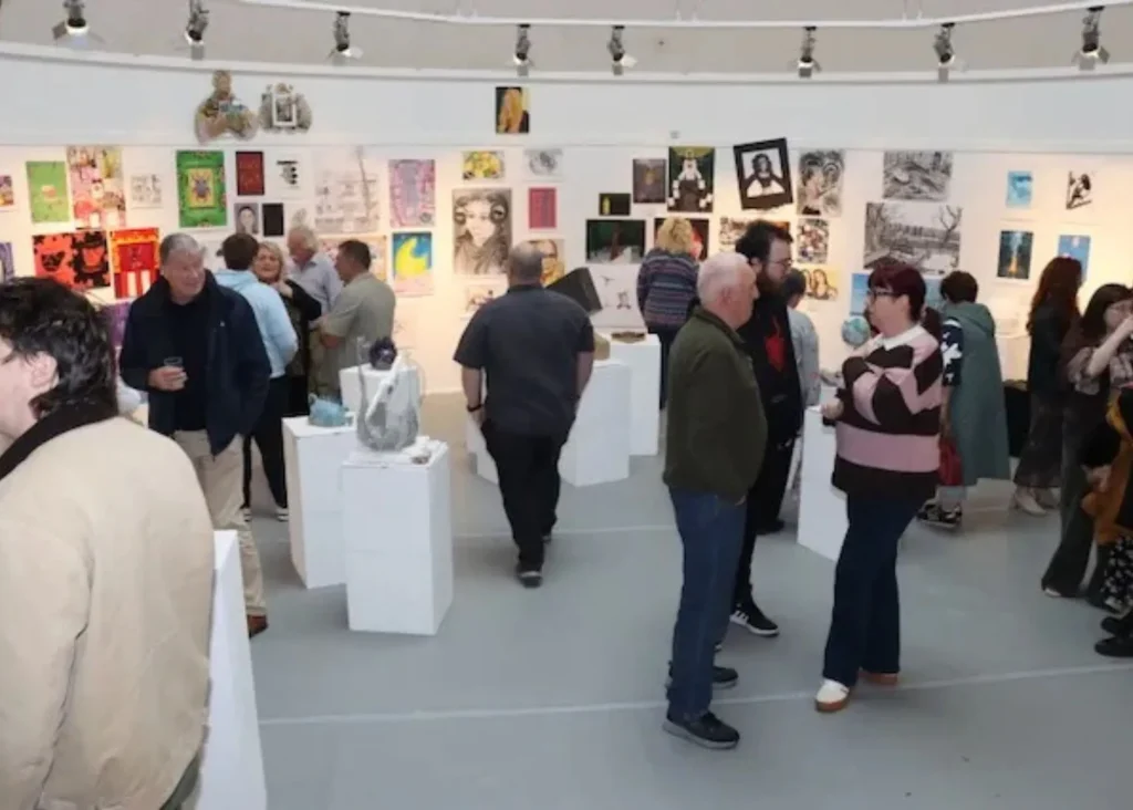 Kerry Coll***A crowd of people looking at art in a gallery