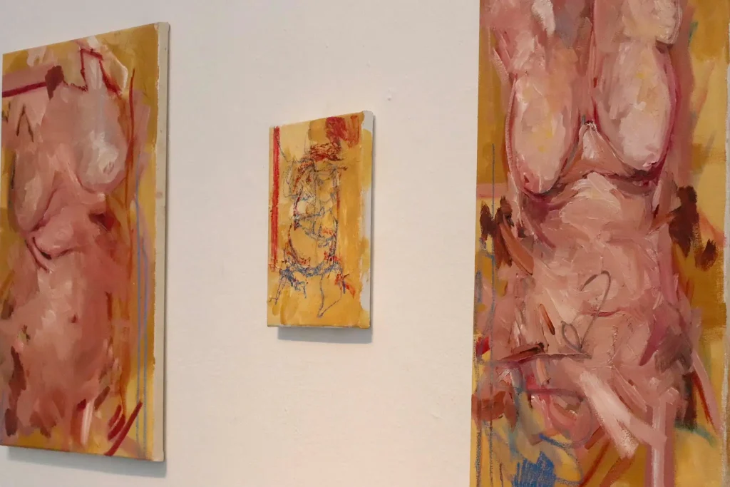 ***Photo of 3 paintings hanging on a white wall.