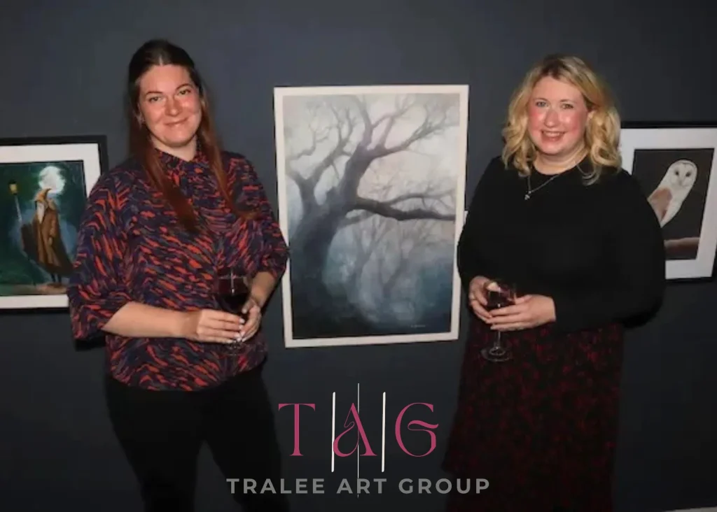 ***Photo of two ladies standing either side of a painting. Logo Text "Tralee Art Group"
